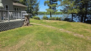 A house with a deck overlooking a lake, surrounded by trees. - Secluded 2 acre Lakeside Home, boat & motor included on 5 lake chain. free Wi-Fi (Eagle River)