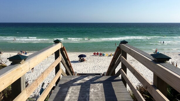 A wooden boardwalk leading to a beach with people sunbathing and swimming. - Luxe gulf side living between Rosemary & Alys - walk to beach & oceanfront pool  (Panama City Beach)