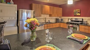 A modern kitchen with stainless steel appliances, wooden cabinets, and a granite countertop. - Purple Juniper: Downtown witth Sunny Front Deck (Durango)