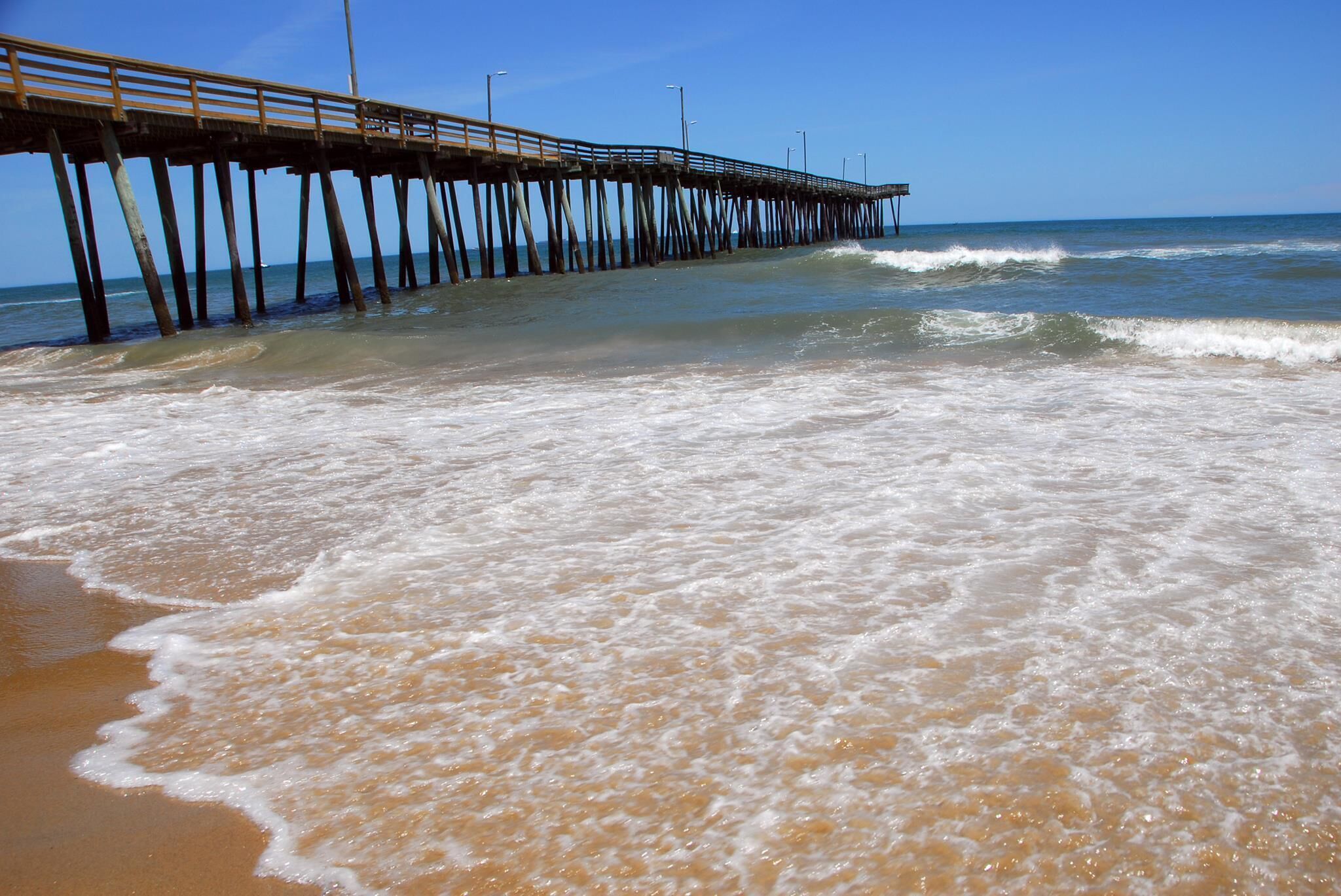 Une jetée qui s’avance dans l’océan, avec des vagues qui se brisent sur le rivage.