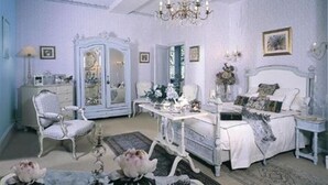 Une chambre à coucher classique, avec un lit à baldaquin, une coiffeuse, une chaise et une armoire.