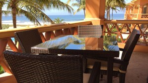 A table and chairs on an outdoor balcony with a view of the ocean. - 2 BR condo nestled between Pacific Ocean beach and golf course    (Mazatlan)