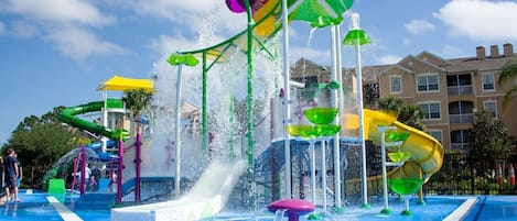 A water park with multiple slides and water features, surrounded by buildings.