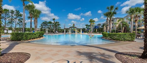 A pool area with palm trees, a gazebo, and a clear blue sky.