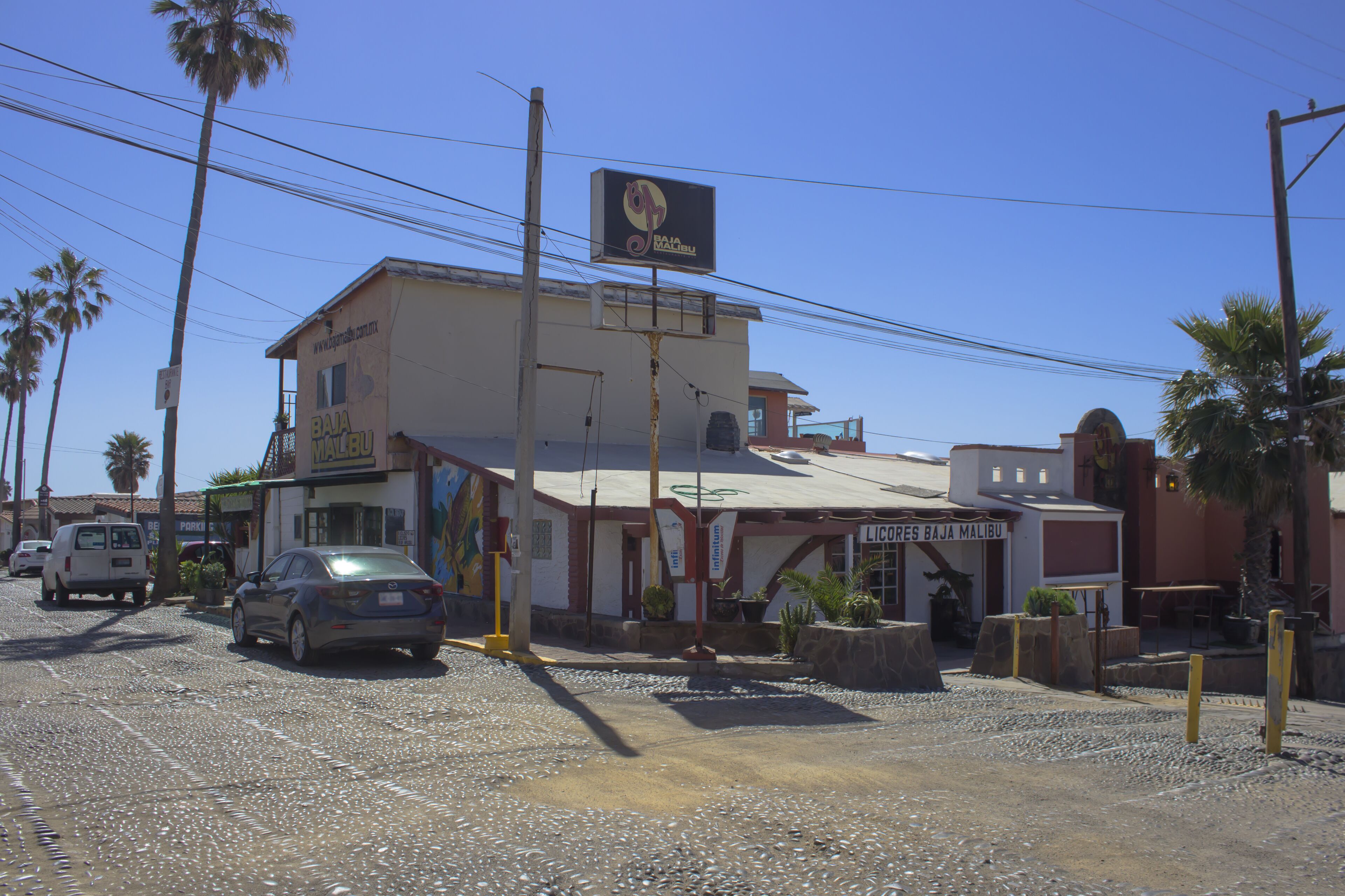Un bâtiment sur lequel on peut lire l’inscription « Baja Malibu », avec une voiture garée devant.