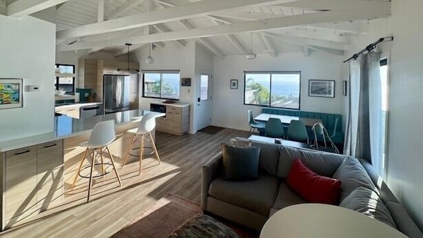 Amplia sala de estar con techo alto, cocina y comedor con vistas.
