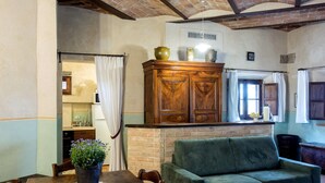 Una sala acogedora con una mesa de comedor de madera, un sofá verde y una chimenea de ladrillo.