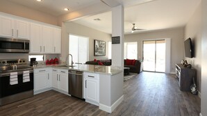 Una cocina moderna con armarios blancos, electrodomésticos de acero inoxidable y una isla central.