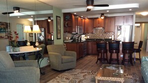 A spacious living room with a large armchair, a coffee table, and a patterned rug.