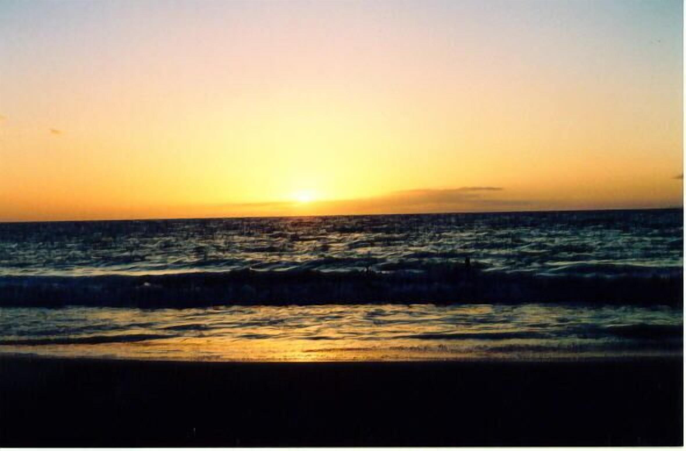 Atardecer sobre el océano con olas.