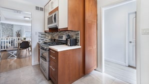 A modern kitchen with wooden cabinets, a microwave, a stove, and a countertop. - Stylish Modern Home ★ Heart of Hollywood & Walkable ★ 2 Private Car Spots (Los Angeles)