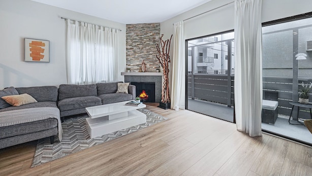 A modern living room with a grey sectional sofa, a white coffee table, and a fireplace. - Stylish Modern Home ★ Heart of Hollywood & Walkable ★ 2 Private Car Spots (Los Angeles)
