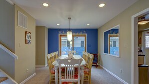 A dining area with a round table and chairs, a chandelier, and a view through the window. - WALK EVERYWHERE!  SPACIOUS 4BR HOUSE, IN-TOWN REHOBOTH BEACH! PET-FREE. (Rehoboth Beach)