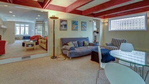 A cozy living room with a sofa, a coffee table, and a glass-top table with chairs. - WALK EVERYWHERE!  SPACIOUS 4BR HOUSE, IN-TOWN REHOBOTH BEACH! PET-FREE. (Rehoboth Beach)