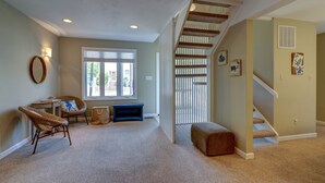 A spacious room with a staircase, a window with blinds, and a wall-mounted mirror. - WALK EVERYWHERE!  SPACIOUS 4BR HOUSE, IN-TOWN REHOBOTH BEACH! PET-FREE. (Rehoboth Beach)