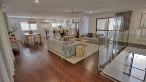 A spacious living area with a dining table, sofas, and a kitchen in the background. - Hidden Oasis - Peregian Beach (Peregian Beach)
