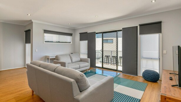 A modern living room with a sofa, a glass coffee table, and a TV on a wooden stand. - Beachy Keen - sleeps 11 (COWES)