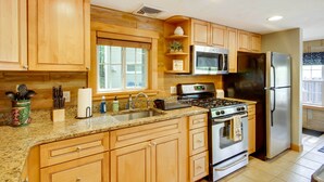 A kitchen with wooden cabinets, a granite countertop, a stainless steel refrigerator, a microwave, and an oven. - Laconia Home w/ Beach - 1/2 Mi to Weirs Beach (Laconia)