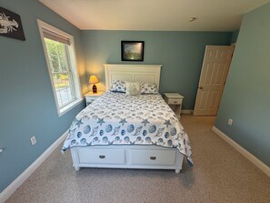 A bedroom with a bed, a nightstand, a lamp, a door, and a window. - Close to Rockland, large mid coast home in quiet neighborhood (South Thomaston)