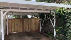 A covered patio area with a wooden fence and a white pergola structure. - Fay Cottage - Convenience in the heart of La Jolla village of La Jolla (La Jolla)