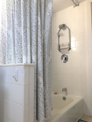 Bathtub, hair dryer, towels, shampoo
