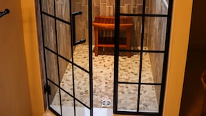 A room with a large window, a wooden bench, and a tiled floor.