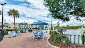 A waterfront patio with outdoor seating, a pool, and a view of the lake.