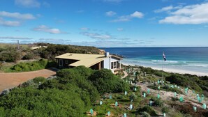 A coastal property with a house overlooking the beach, a flagpole with a flag, and a cemetery with headstones. - King George Beach Retreat (Middle River)
