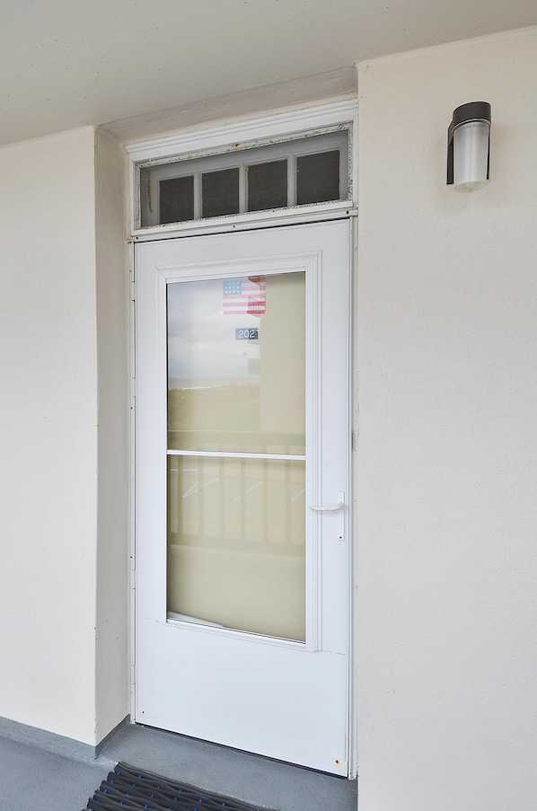 Eine weiße Tür mit einer satinierten Glasverkleidung und einem kleinen Fenster darüber.