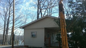 Eine kleine, eingeschossige Holzhütte mit Veranda und kleinem Fenster.