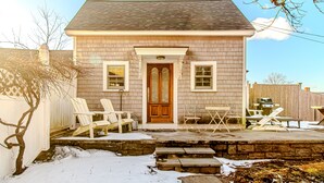 A two-story house with a front porch, a wooden door, and a brick exterior.
