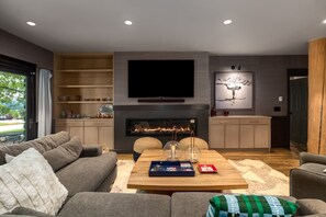 A modern living room with a fireplace, a flat-screen TV, and a cozy seating area. - *Rare Find* Mark Twain Lodge by MVL - Luxury Cabin with Hot Tub - EZ Cancel (Steamboat Springs)