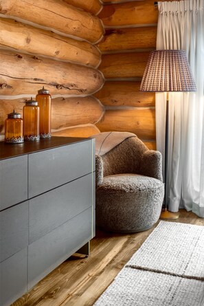 A log cabin interior with a gray dresser, a round armchair, a lamp, and jars on the dresser. - *Rare Find* Mark Twain Lodge by MVL - Luxury Cabin with Hot Tub - EZ Cancel (Steamboat Springs)