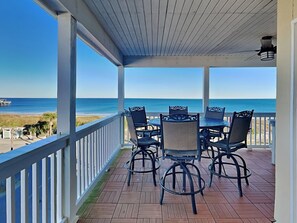A covered outdoor seating area with a view of the ocean.