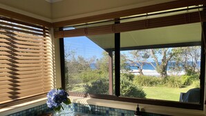 A kitchen with a window overlooking a garden and the sea. - ABSOLUTE Mollymook BEACHFRONT- Direct beach access  and views / Wifi / Smart TV  (Mollymook Beach)