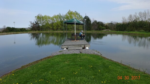 A tranquil lakeside scene with a wooden dock and a covered seating area. -  Rest and relax- great view of Hemlock hills and surrounding area.  (Hemlock)