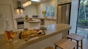 Een moderne keuken met een centraal eiland, roestvrijstalen apparatuur en uitzicht op de omgeving.