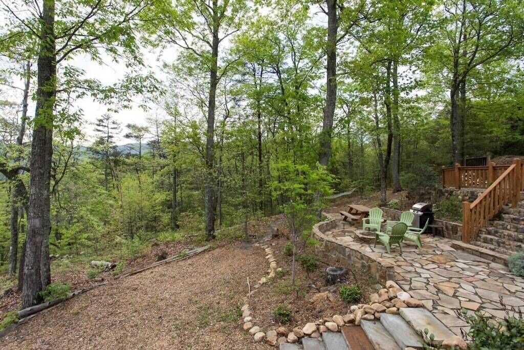 A stone patio with outdoor seating and a wooden deck.