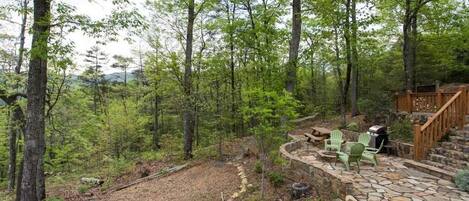 A stone patio with outdoor seating and a wooden deck.