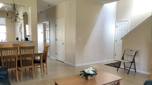 A spacious living room with a dining area, a staircase, and a kitchen in the background. - Lovely 2 King Size Ensuite BR , 3 Mi to Disney, 1min to Pool, Free WiFi &Parking (Kissimmee)