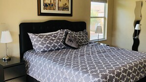 A bedroom with a bed, a nightstand, a lamp, a window, and a framed picture on the wall. - Lovely 2 King Size Ensuite BR , 3 Mi to Disney, 1min to Pool, Free WiFi &Parking (Kissimmee)