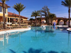A resort pool area with lounge chairs and palm trees. - Lovely 2 King Size Ensuite BR , 3 Mi to Disney, 1min to Pool, Free WiFi &Parking (Kissimmee)