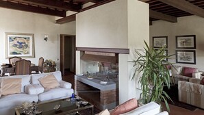 A living room with a fireplace, sofas, a coffee table, and framed artwork on the walls.