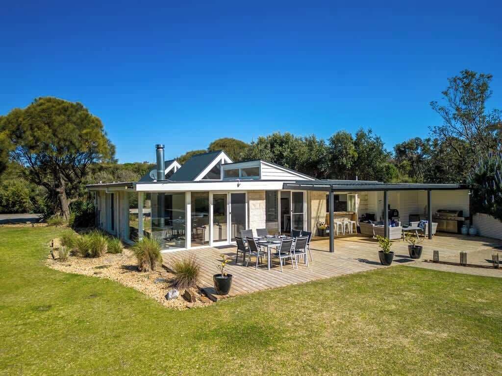 A modern house with a covered patio, a dining area, and a kitchen.