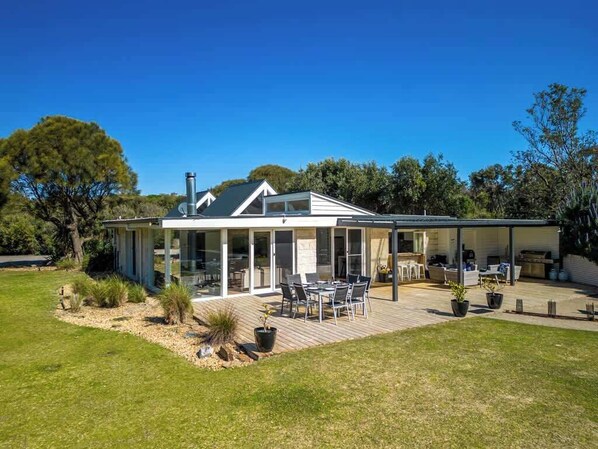 A modern house with a covered patio, a dining area, and a kitchen.