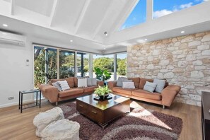 A modern living room with a stone wall, a sectional sofa, and a coffee table.