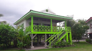 A two-story house with a green balcony and stairs. - Bungalow 15 - Beachfront Pool View Private Gem! (Playa Hermosa)