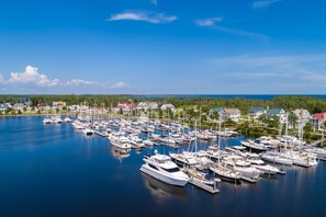 Boats docked in a serene marina surrounded by homes and lush greenery.