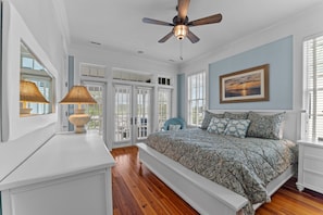 A bedroom with a large bed, a ceiling fan, a window with blinds, and a painting on the wall. - Sunnyside 6 - Beautiful Harborside retreat! (Oriental)