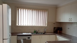 A kitchen with a dishwasher, a sink, and cabinets. - The Bottlebrush, 2 bedroom, Villa Unit, Townhouse (Tumut)